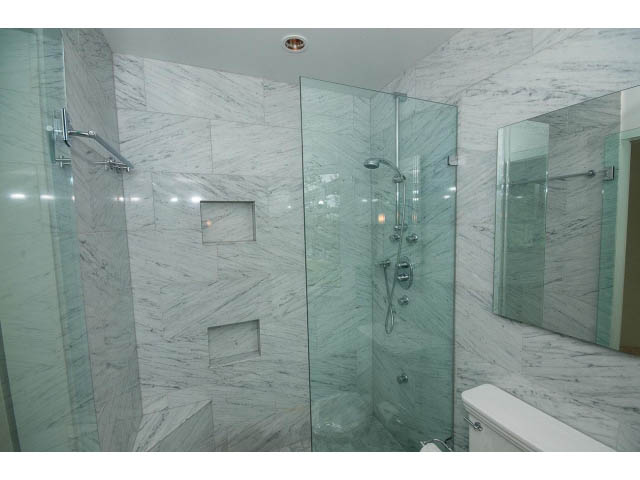 Spacious bathroom with marble walls and glass shower, modern fixtures. - 3890 Sharon Drive, West Vancouver