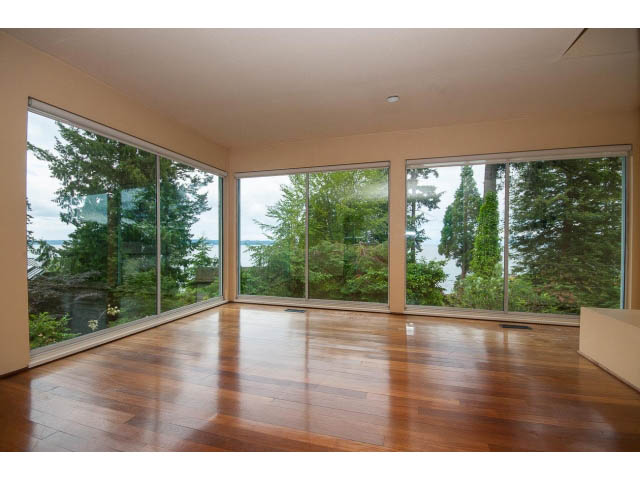 Spacious living room with hardwood floors and a stunning view of the forest. - 3890 Sharon Drive, West Vancouver