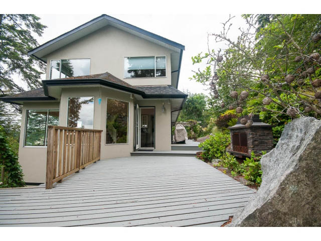 Bright deck with modern house and lush greenery in the background. - 3890 Sharon Drive, West Vancouver