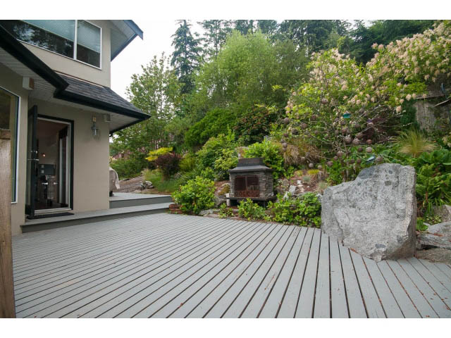 Furnished deck with stone accents and lush greenery. - 3890 Sharon Drive, West Vancouver