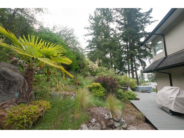 Bright patio with lush greenery and a view of the water. - 3890 Sharon Drive, West Vancouver