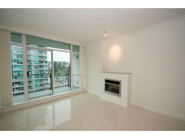Spacious living room with glossy white countertops and city view. - 1101 - 172 Victory Ship Way, North Vancouver