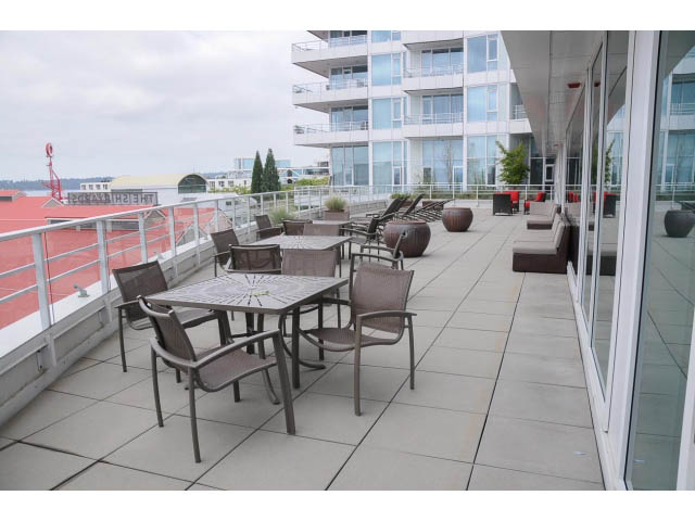 Furnished balcony with outdoor seating and city view. - 1101 - 172 Victory Ship Way, North Vancouver