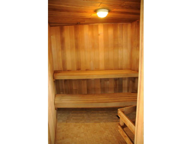 Furnished living room with wooden walls and ceiling, cozy ambiance. - 1101 - 172 Victory Ship Way, North Vancouver
