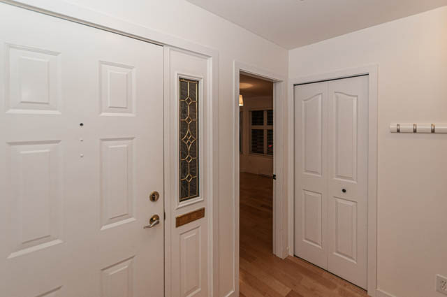 Bright hallway leading to a cozy bedroom with hardwood floors and a decorative door panel. - 2263 Heather st., Vancouver West Side