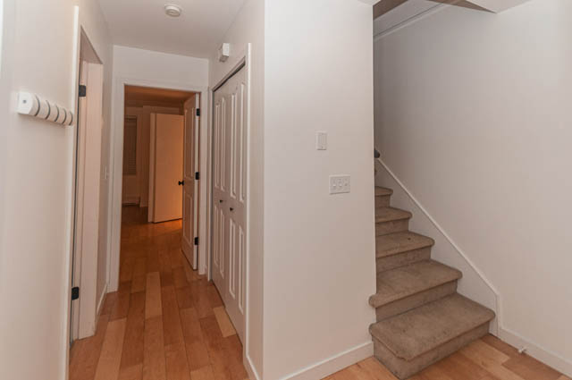 Bright hallway leading to bedrooms with hardwood floors and a staircase. - 2263 Heather st., Vancouver West Side