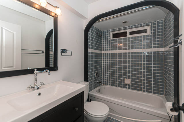 Bright bathroom with white countertops and black-framed mirror. - 2263 Heather st., Vancouver West Side