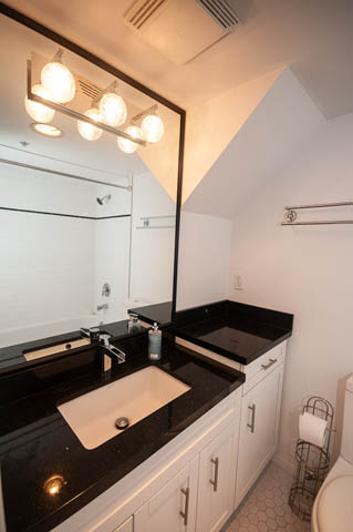 Bathroom with black countertops and modern lighting fixture. - 2263 Heather st., Vancouver West Side