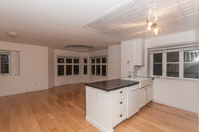 Bright kitchen with white cabinetry, hardwood floors, and large windows. - 2263 Heather st., Vancouver West Side