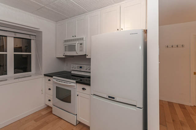 Bright kitchen with white cabinets, stainless steel appliances, and hardwood floors. - 2263 Heather st., Vancouver West Side