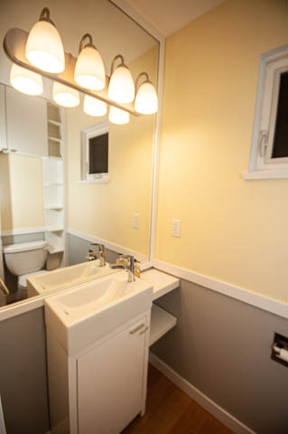 Bright bathroom with white sink, wooden countertop, and light wood flooring. - 2263 Heather st., Vancouver West Side