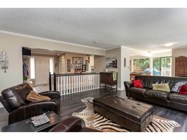 Furnished living room with leather sofas, zebra-patterned rug, and hardwood floors. - 3243 Milton Ave., North Vancouver
