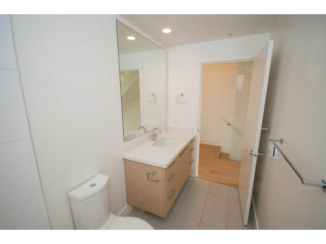 Furnished bathroom with wooden cabinets and a large mirror. - 3187 St. George St., Vancouver East Side
