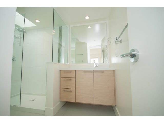 Furnished bathroom with modern vanity, glass shower, and light wood cabinets. - 3187 St. George St., Vancouver East Side
