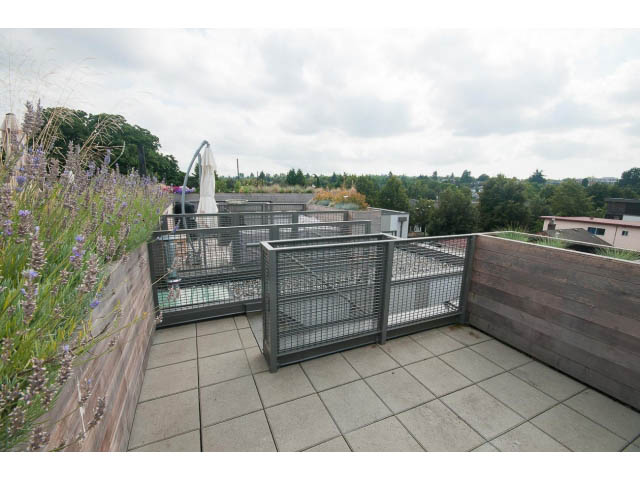 Furnished rooftop patio with wooden railings and city view. - 3187 St. George St., Vancouver East Side