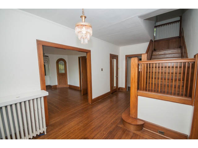 Furnished living room with hardwood floors and wooden staircase leading to upper level. - 5756 Angus Drive, Vancouver West Side
