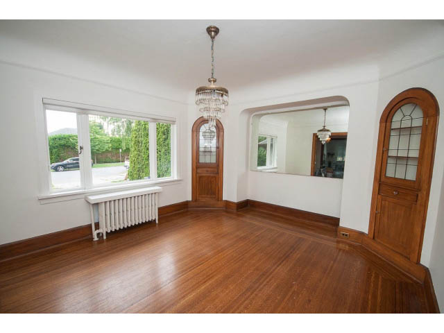 Spacious living room with hardwood floors, arched windows, and a chandelier. - 5756 Angus Drive, Vancouver West Side