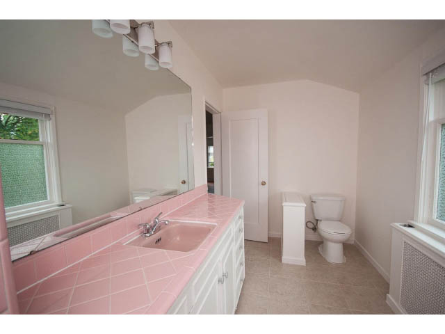Bright bathroom with pink countertops and white cabinetry. - 5756 Angus Drive, Vancouver West Side