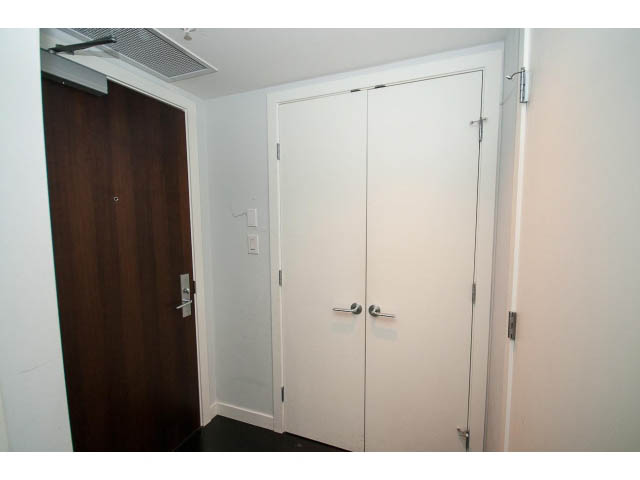 Bright hallway with white doors and dark wood accents. - 1106 - 788 Richards, Vancouver Downtown