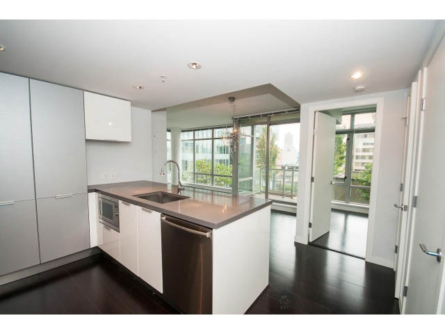 Bright kitchen with white cabinetry, dark hardwood floors, and a city view. - 1106 - 788 Richards, Vancouver Downtown