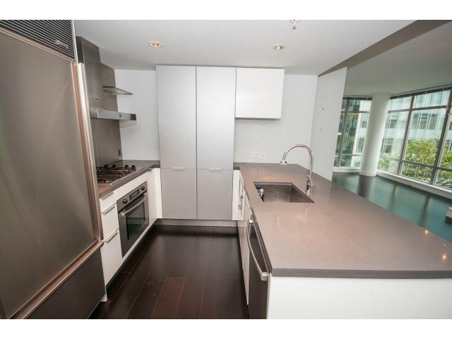 Bright kitchen with modern stainless steel appliances, dark hardwood floors, and a city view. - 1106 - 788 Richards, Vancouver Downtown