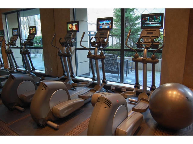 Bright fitness room with cardio equipment and large windows, city view. - 1106 - 788 Richards, Vancouver Downtown