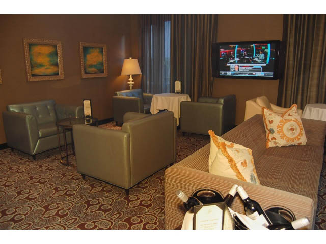 Furnished living room with comfortable seating, patterned carpet, and a TV displaying a sports game. - 1106 - 788 Richards, Vancouver Downtown