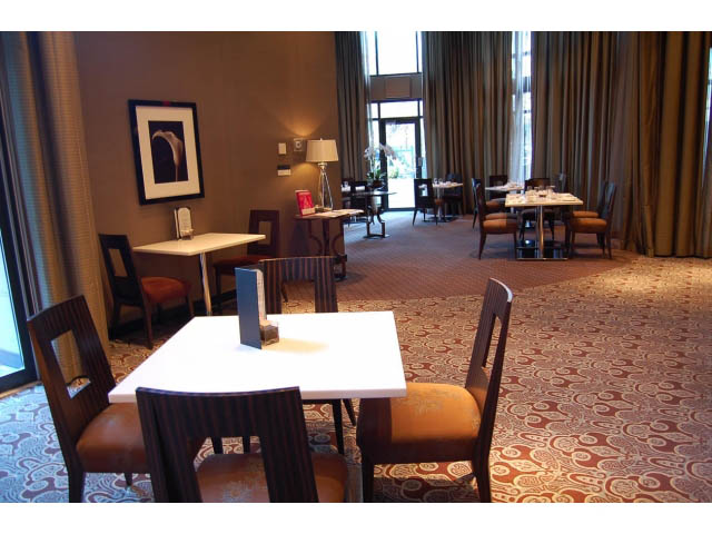 Furnished dining area with patterned carpet, wooden chairs, and large windows. - 1106 - 788 Richards, Vancouver Downtown