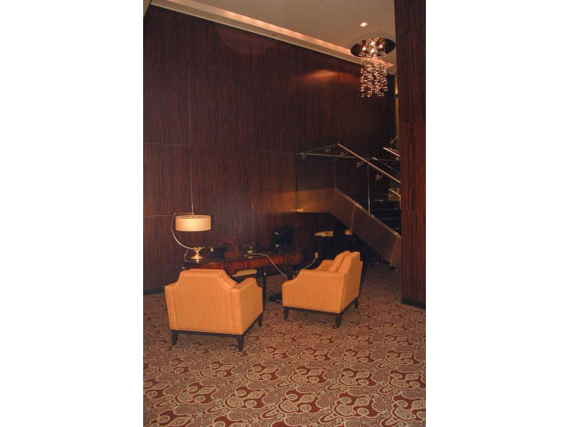 Furnished living room with patterned carpet and wooden panel walls. - 1106 - 788 Richards, Vancouver Downtown