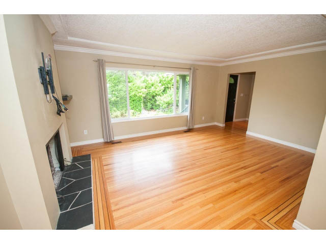 Bright living room with hardwood floors and large window view. - 549 W Queens, North Vancouver