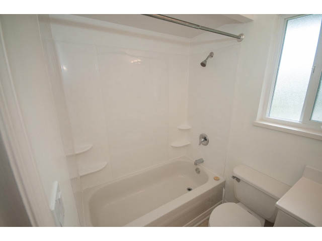 Bright bathroom with white fixtures and a window. - 549 W Queens, North Vancouver