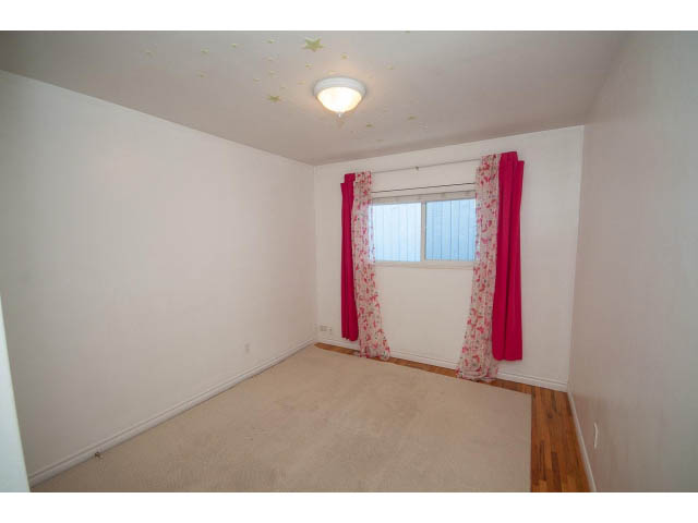 Bright bedroom with hardwood floors and star ceiling details. - 549 W Queens, North Vancouver