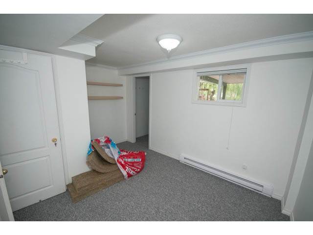 Bright bedroom with carpet, small window, and white walls. - 549 W Queens, North Vancouver