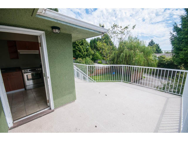 Bright kitchen with green walls, stainless steel appliances, and a view of the backyard. - 549 W Queens, North Vancouver