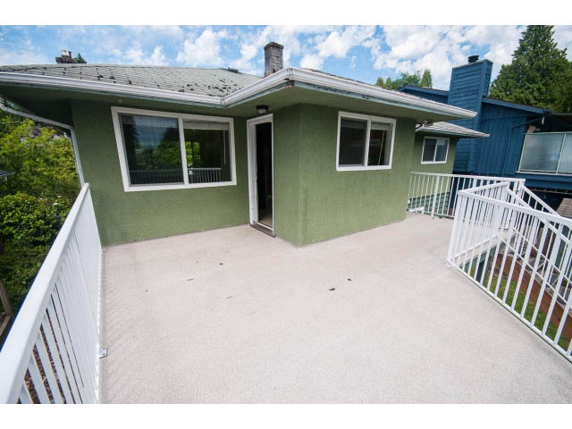 Furnished living room with large windows and a cozy fireplace. - 549 W Queens, North Vancouver