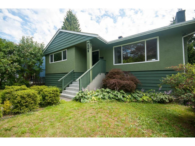 Furnished 5-bedroom house with green siding and a welcoming front porch. - 549 W Queens, North Vancouver