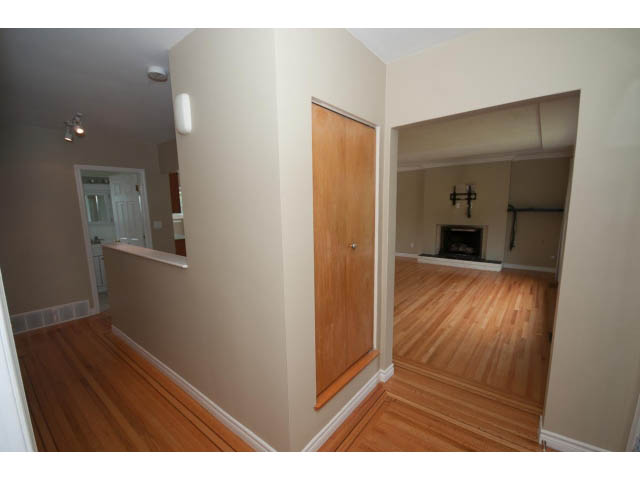 Bright living room with hardwood floors and a sliding door leading to another room. - 549 W Queens, North Vancouver