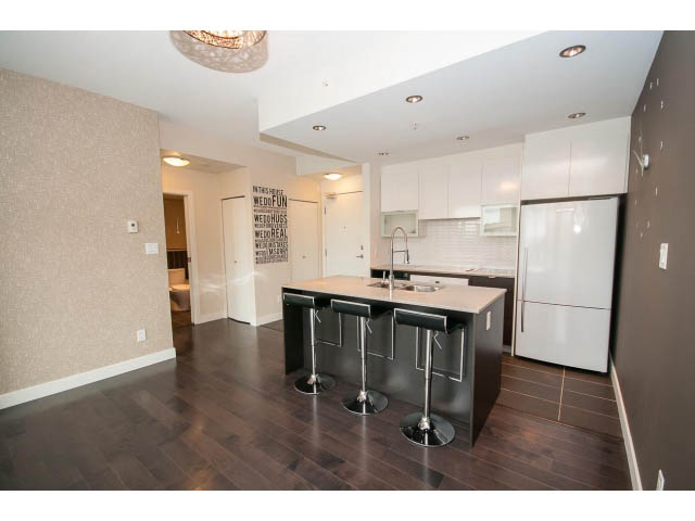 Bright kitchen with modern island, hardwood floors, and white cabinets. - 1105 - 175 West 2nd Street, North Vancouver