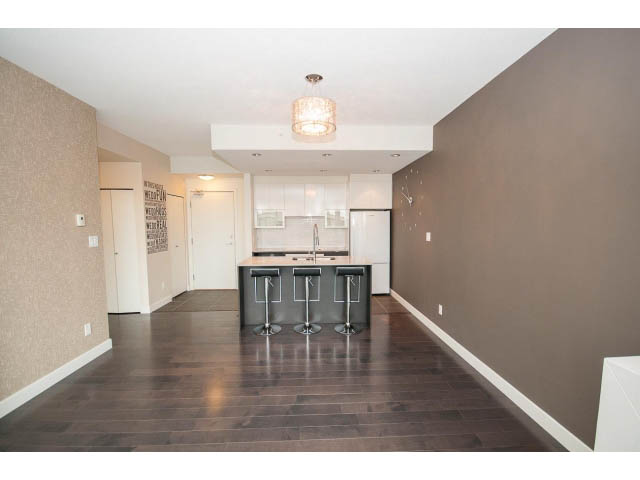 Open-concept living area with hardwood floors and a modern kitchen island. - 1105 - 175 West 2nd Street, North Vancouver