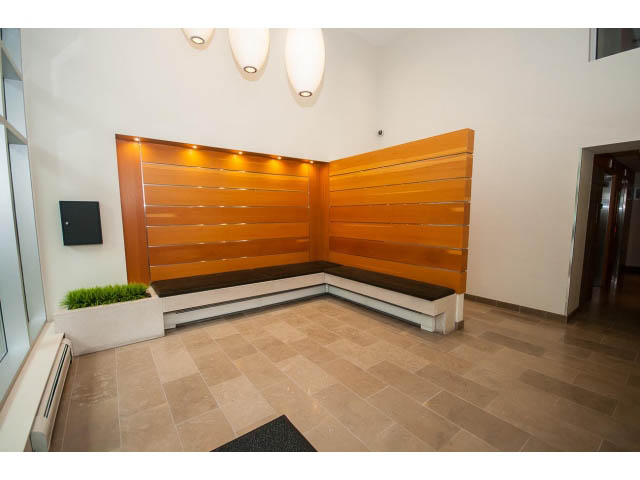 Furnished living room with modern wood paneling and tiled flooring. - 1105 - 175 West 2nd Street, North Vancouver