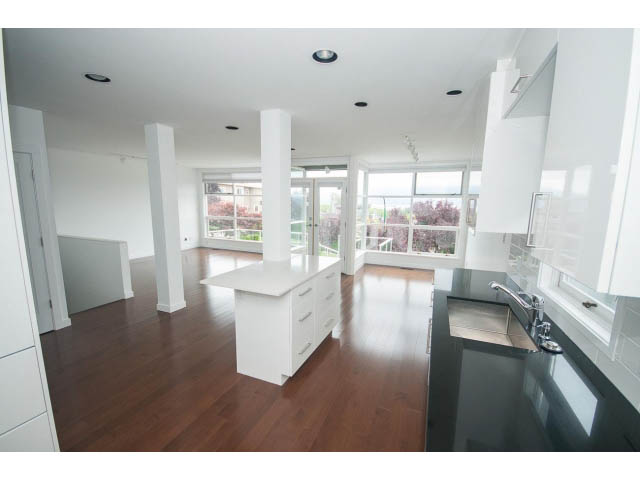 Open-concept living space with hardwood floors and a city view. - 3762 West 13th Ave, Vancouver West Side