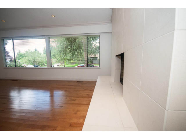 Bright living room with hardwood floors and large windows, offering a city view. - Upper - 1998 Cortell St., North Vancouver