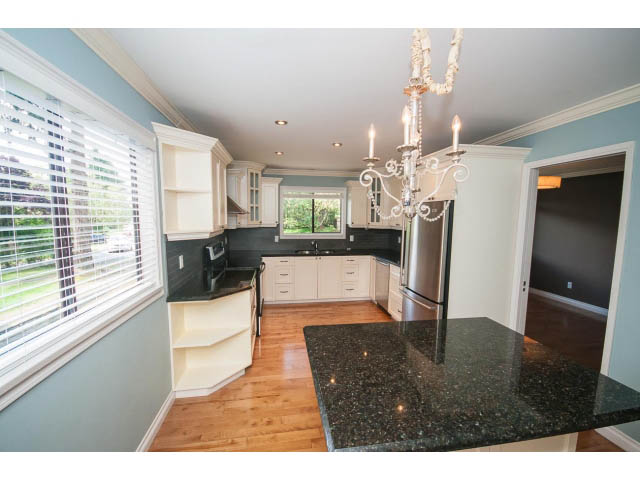 Bright kitchen with granite countertops, hardwood floors, and a chandelier. - Upper - 1998 Cortell St., North Vancouver