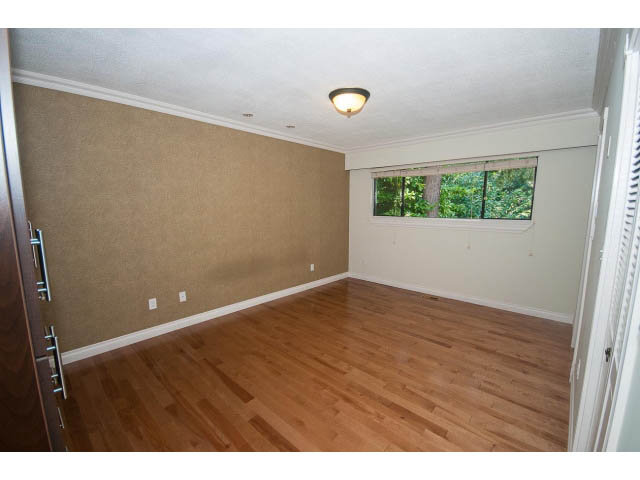 Bright living room with hardwood floors and a view of greenery outside. - Upper - 1998 Cortell St., North Vancouver
