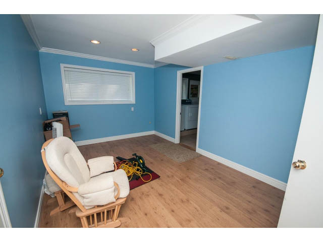 Den with hardwood floors, blue walls, and a glider chair. - Upper - 1998 Cortell St., North Vancouver