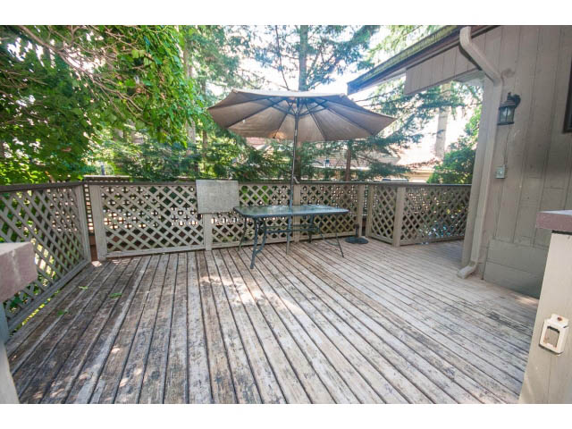 Furnished patio with wooden deck, umbrella, and lattice railing. - Upper - 1998 Cortell St., North Vancouver