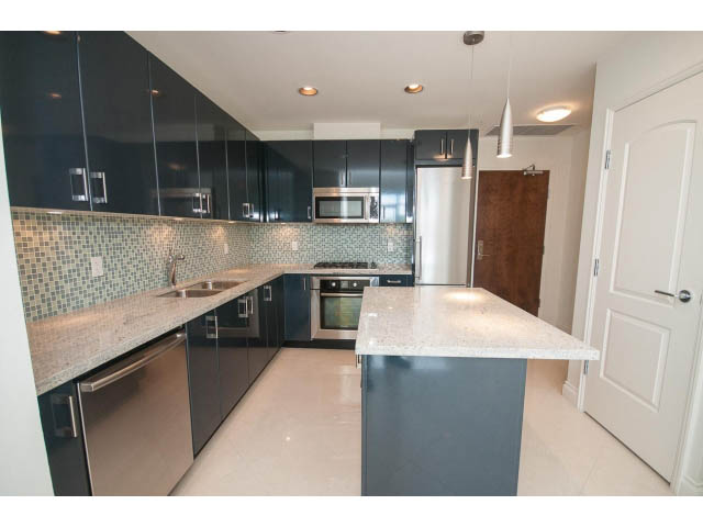 Bright kitchen with granite countertops and stainless steel appliances. - 203 - 162 Victory Ship Way, North Vancouver