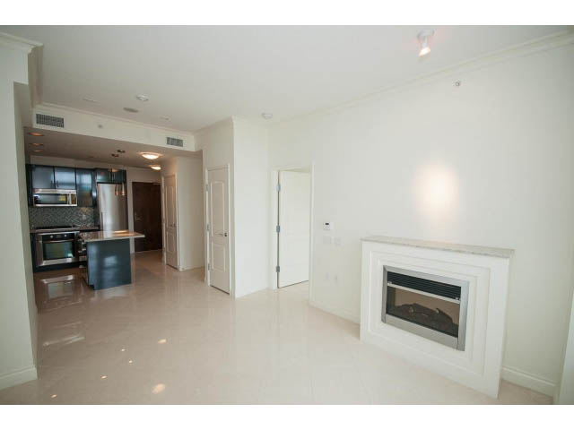 Spacious living room with marble floors and a modern fireplace. - 203 - 162 Victory Ship Way, North Vancouver
