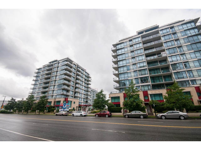 Bright living room with large windows, city view, and modern furnishings. - 203 - 162 Victory Ship Way, North Vancouver