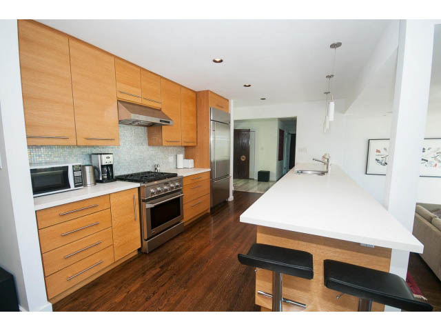 Bright kitchen with white countertops, hardwood floors, and stainless steel appliances. - 6190 Candia Place, West Vancouver